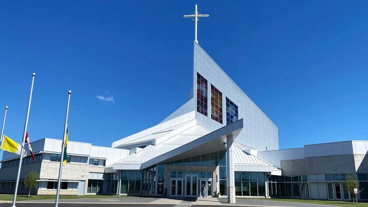 Modern church exterior with a glass entry and cross