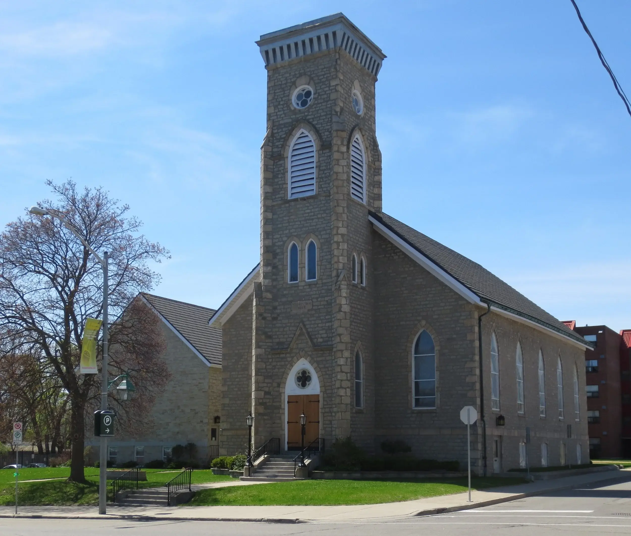 Stone church exterior with steeple and main entrance